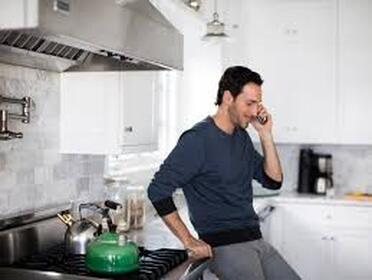 Man in kitchen on phone